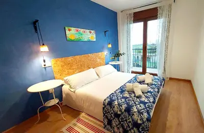 a bedroom with a bed and a table and a window at Masquestar Rías Altas in Foz