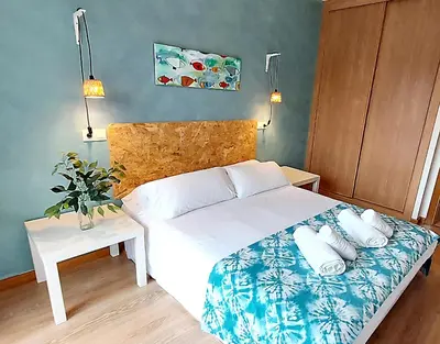 a bedroom with a white bed and a table at Masquestar Rías Altas in Foz