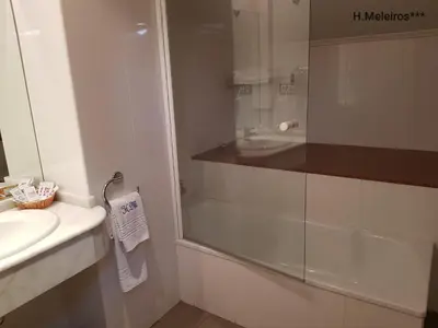 a bathroom with a glass shower and a sink at Hotel Meleiros in Castro de Sanabria