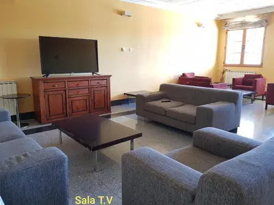 a living room with couches and a flat screen tv at Hotel Meleiros in Castro de Sanabria