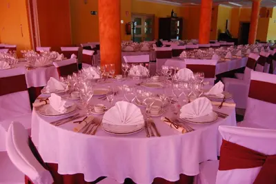 a dining room with white tables and chairs with glasses at Hotel Meleiros in Castro de Sanabria