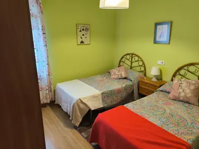 a room with two beds and green walls at Piso Ponferrada in Ponferrada