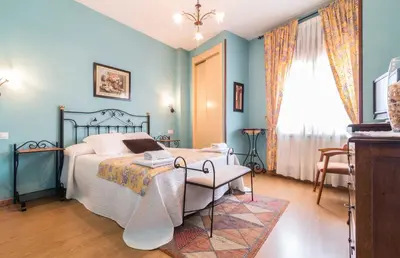 a bedroom with a bed and a table and a window at Hotel Casa Reboiro in Monforte de Lemos