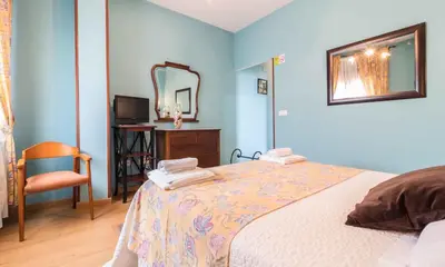 a bedroom with a bed with a mirror and a chair at Hotel Casa Reboiro in Monforte de Lemos