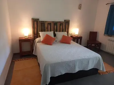 a bedroom with a large bed with two orange pillows at Veiga Mariña in Pontevedra