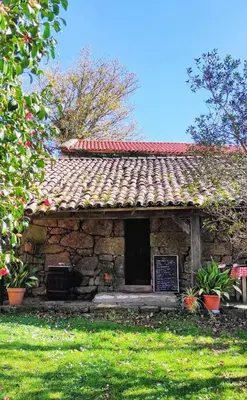 a stone building with a sign in front of it at Veiga Mariña in Pontevedra