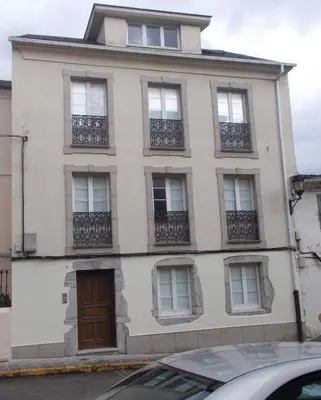 a large white building with windows and a door at Mirador Ría de Ribadeo in Ribadeo