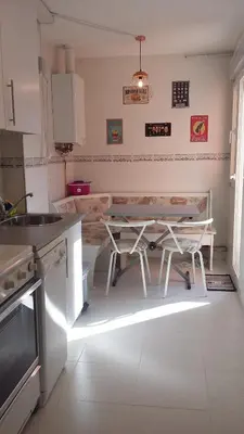 a kitchen with a table and chairs in it at Apartamento en playa de Foz in Foz