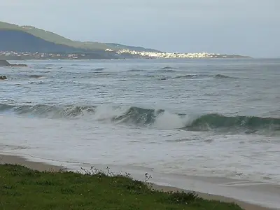 a beach with a body of water with waves at Apartamento en playa de Foz in Foz