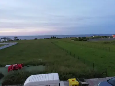 a field of grass with a truck in it at Apartamento en playa de Foz in Foz