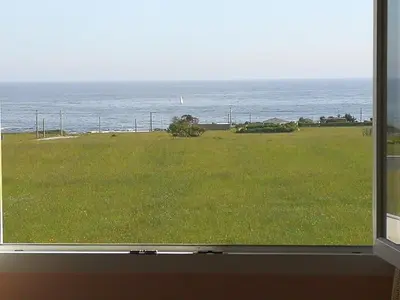 a view of the ocean from a window at Apartamento en playa de Foz in Foz