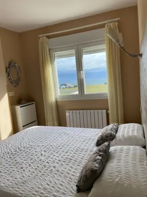 a bedroom with a bed and a window at Apartamento en playa de Foz in Foz