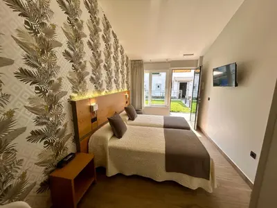a bedroom with a bed and a large window at Casa do Maestro in Portomarin