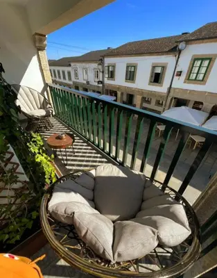a balcony with a wicker chair on a balcony at Casa do Maestro in Portomarin