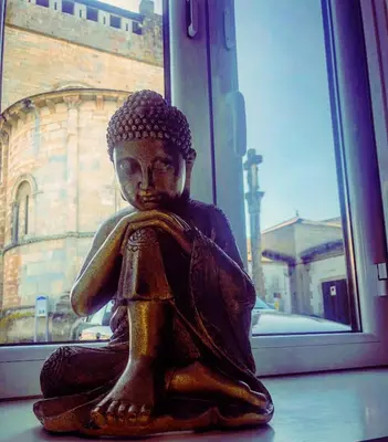 a statue of aitatingitatingitating person sitting in a window at Casa do Maestro in Portomarin