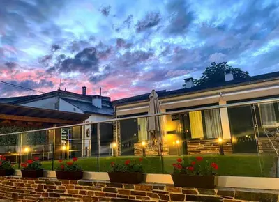 a building with a sunset in the background at Casa do Maestro in Portomarin