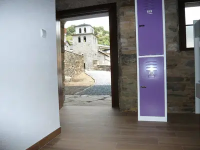 a hallway with a purple door and a building at Albergue El Paso in Vega de Valcarce
