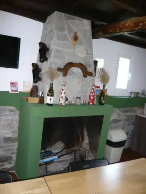a fireplace in a living room with a green mantle at Albergue El Paso in Vega de Valcarce