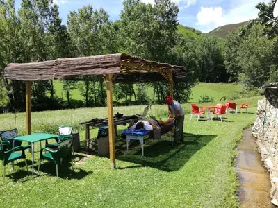 a man laying in a chair under a pavilion at Albergue El Paso in Vega de Valcarce