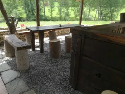 a wooden table and some stools and a bench at Albergue El Paso in Vega de Valcarce