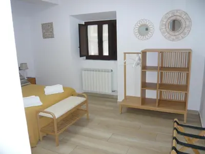 a living room with a table and a shelf at Albergue El Paso in Vega de Valcarce