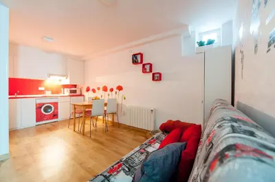 a living room with a red couch and a kitchen at Entrepexigos in Santiago de Compostela