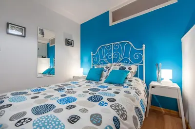 a blue bedroom with a bed with a blue accent wall at Entrepexigos in Santiago de Compostela