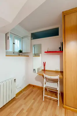 a kitchen with a table and a chair in a room at Entrepexigos in Santiago de Compostela