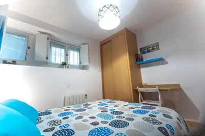 a bedroom with a bed with a blue and white comforter at Entrepexigos in Santiago de Compostela