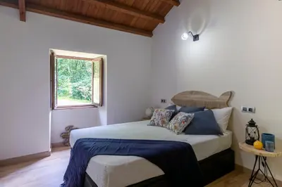 a bedroom with a bed and a window at Casas del Molino - Muiños do Mainzoso Turismo Rural in Paderne