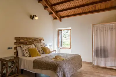 a bedroom with a bed with a hat on it at Casas del Molino - Muiños do Mainzoso Turismo Rural in Paderne
