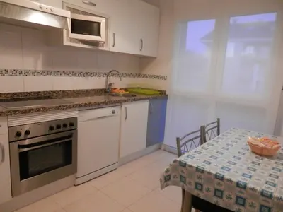 a kitchen with a table and a stove top oven at Apartamento Dicar in Foz