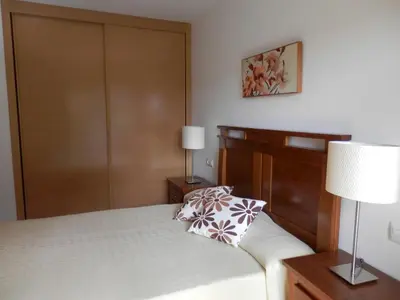 a bedroom with a bed with a wooden door at Apartamento Dicar in Foz