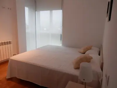 a bedroom with a white bed with two pillows at Apartamento Dicar in Foz
