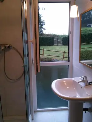 a bathroom with a shower and a sink and a window at Apartamento Dicar in Foz