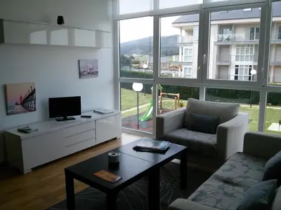 a living room with a couch and a tv and a table at Apartamento Dicar in Foz
