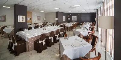 a dining room with white tables and chairs at ARNOIA CALDARIA HOTEL Y BALNEARIO in Arnoia