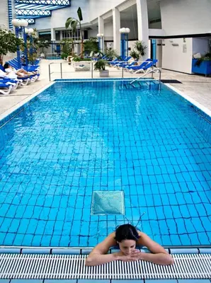 a woman laying on a chair in a swimming pool at ARNOIA CALDARIA HOTEL Y BALNEARIO in Arnoia