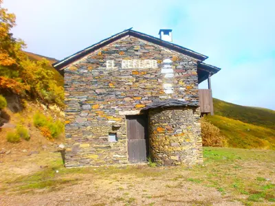 an old stone building with a door on a hill at El Balcón de Sotillo - Las Médulas - Senderismo por Canales Romanos in Sotillo de Cabrera