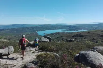 two people walking down a trail on a mountain at Apartamento Carballo Do Xurès in Maus de Salas