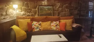 a couch with colorful pillows on it in a room at Casa do Xurés in Maus de Salas