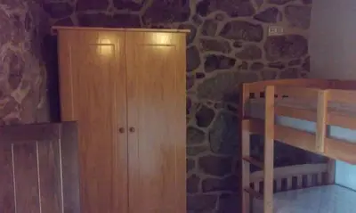 a bedroom with a wooden cabinet and a bunk bed at Casa do Xurés in Maus de Salas
