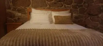 a bed with white sheets and pillows in a room at Casa do Xurés in Maus de Salas