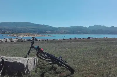 a bike laying on a rock next to a body of water at Casa do Xurés in Maus de Salas