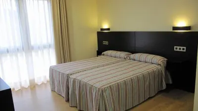 a bedroom with a bed with a black head board at Hotel Amenal in Amenal