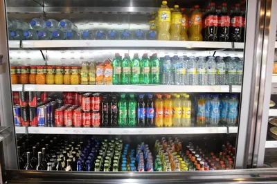 a refrigerator filled with lots of different colored soda bottles at Hotel Amenal in Amenal