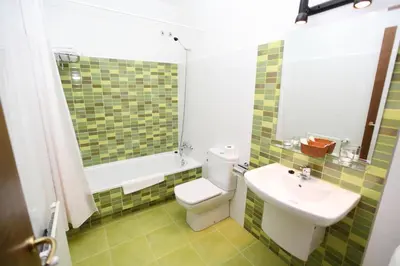 a bathroom with a white toilet and a sink at Hotel Amenal in Amenal