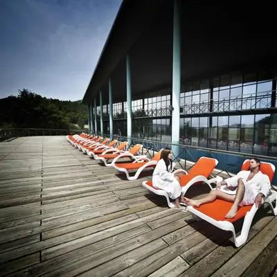 a group of people sitting on lounge chairs on a building at Laias Caldaria hotel y Balneario in Laias