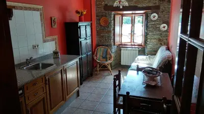 a kitchen with a sink and a table and a window at Apartamentos Los Castros in San Tirso de Abres