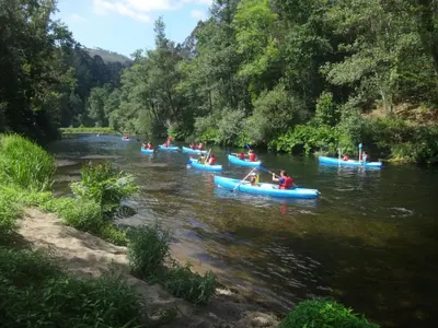 a group of people in blue kayaks on a river at Apartamentos Los Castros in San Tirso de Abres